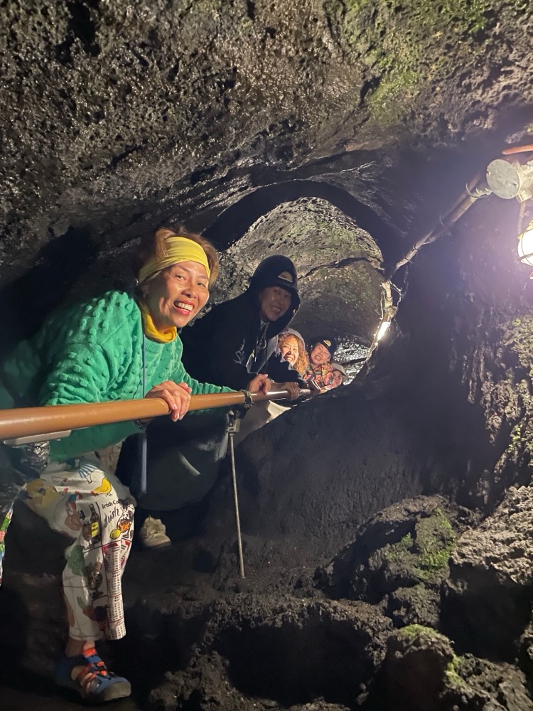 Guests smiling as they explore a lava cave