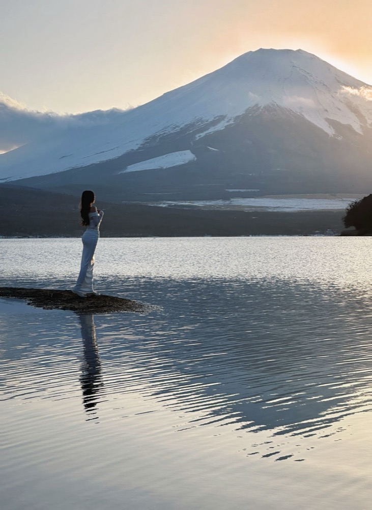A guest standing by the lake at dusk, facing Mt. Fuji